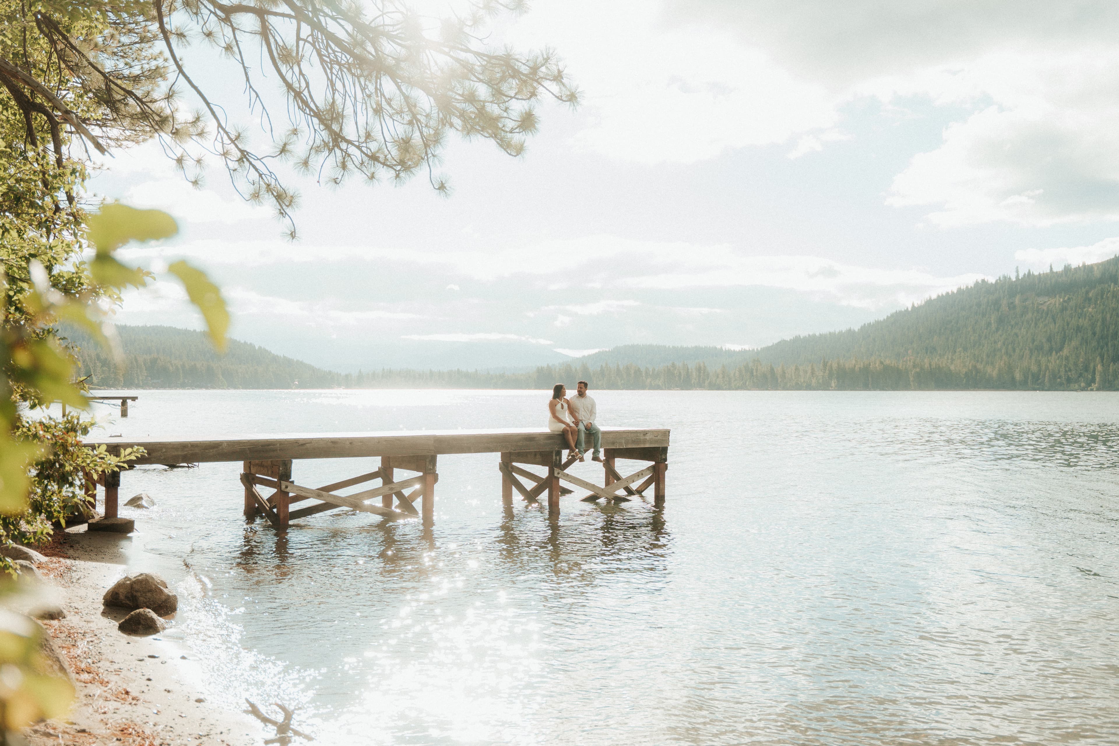 Norma and Jose sitting on a dock at the lake